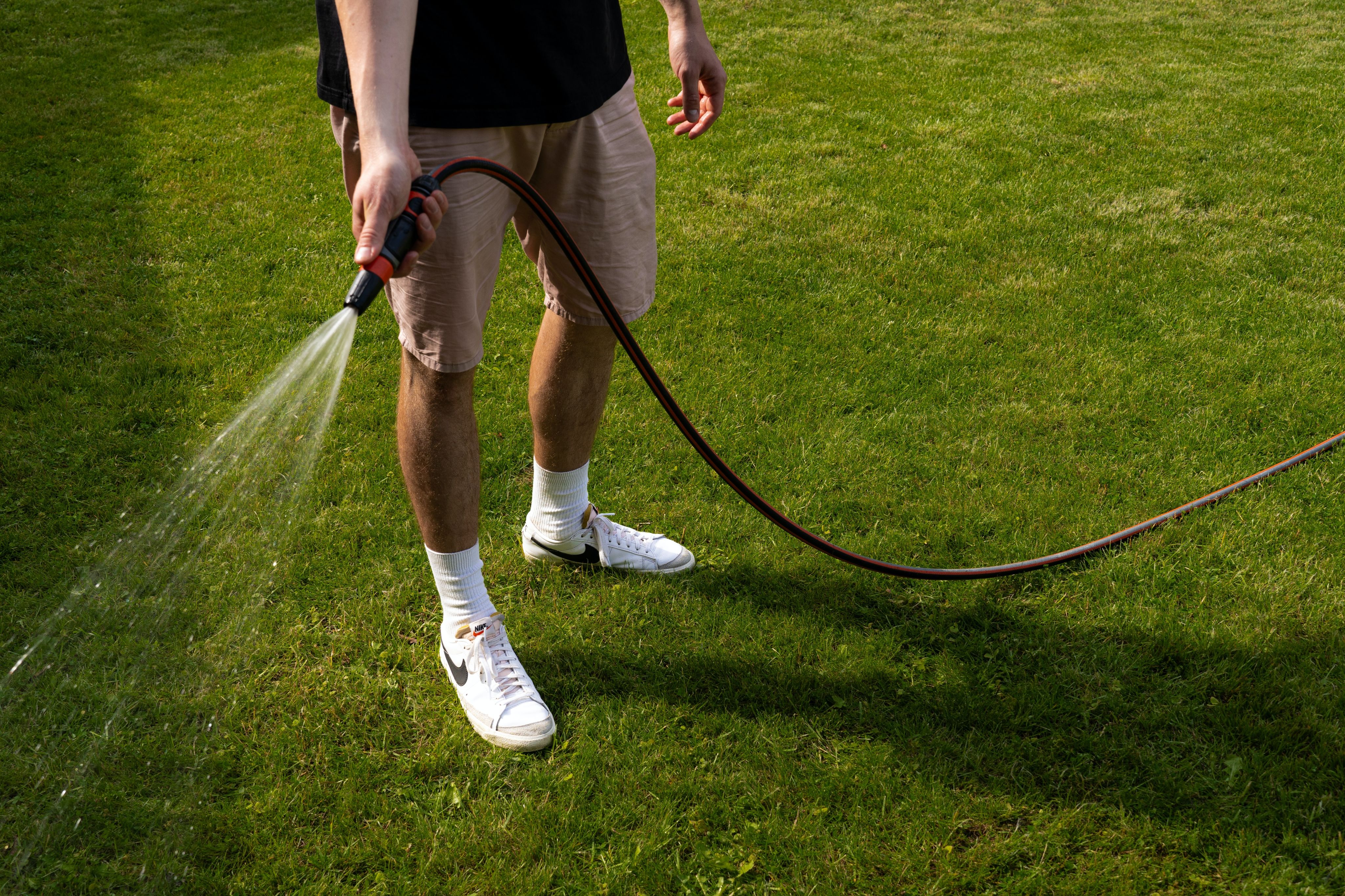 a man is spraying water on the grass